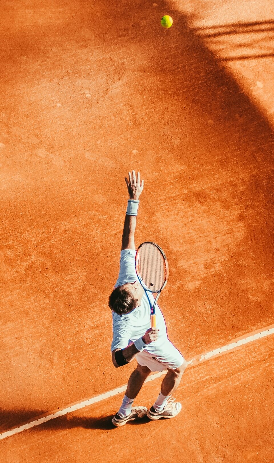 Tennis player serving on a clay court